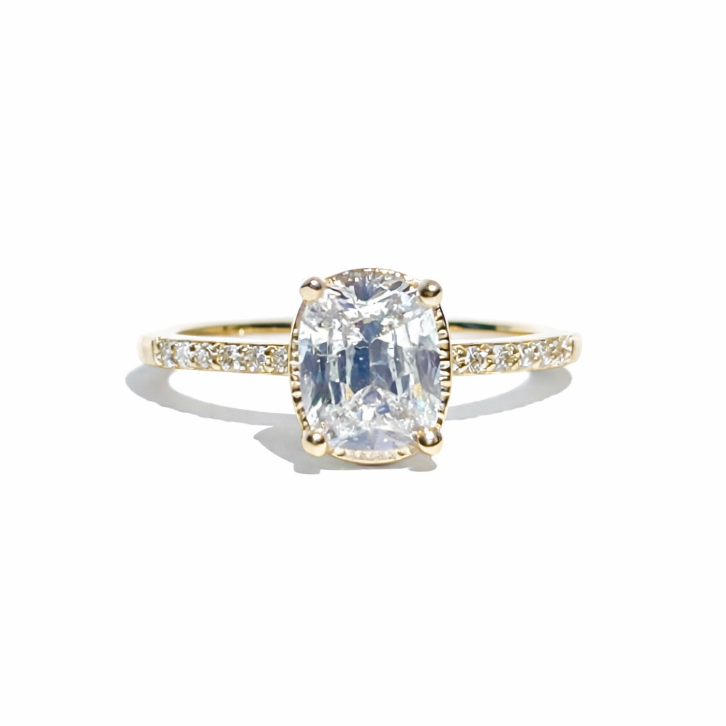 Gold ring with a large diamond and smaller diamonds on the band against a white background