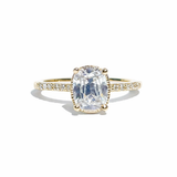 Gold ring with a large diamond and smaller diamonds on the band against a white background
