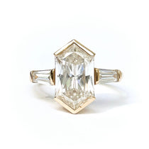 Gold ring with a large rectangular diamond on a white background