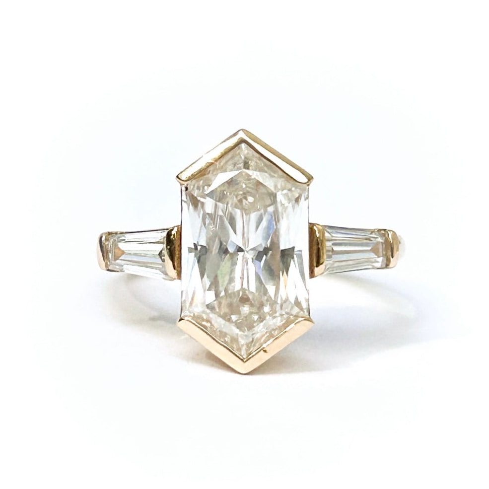 Gold ring with a large rectangular diamond on a white background