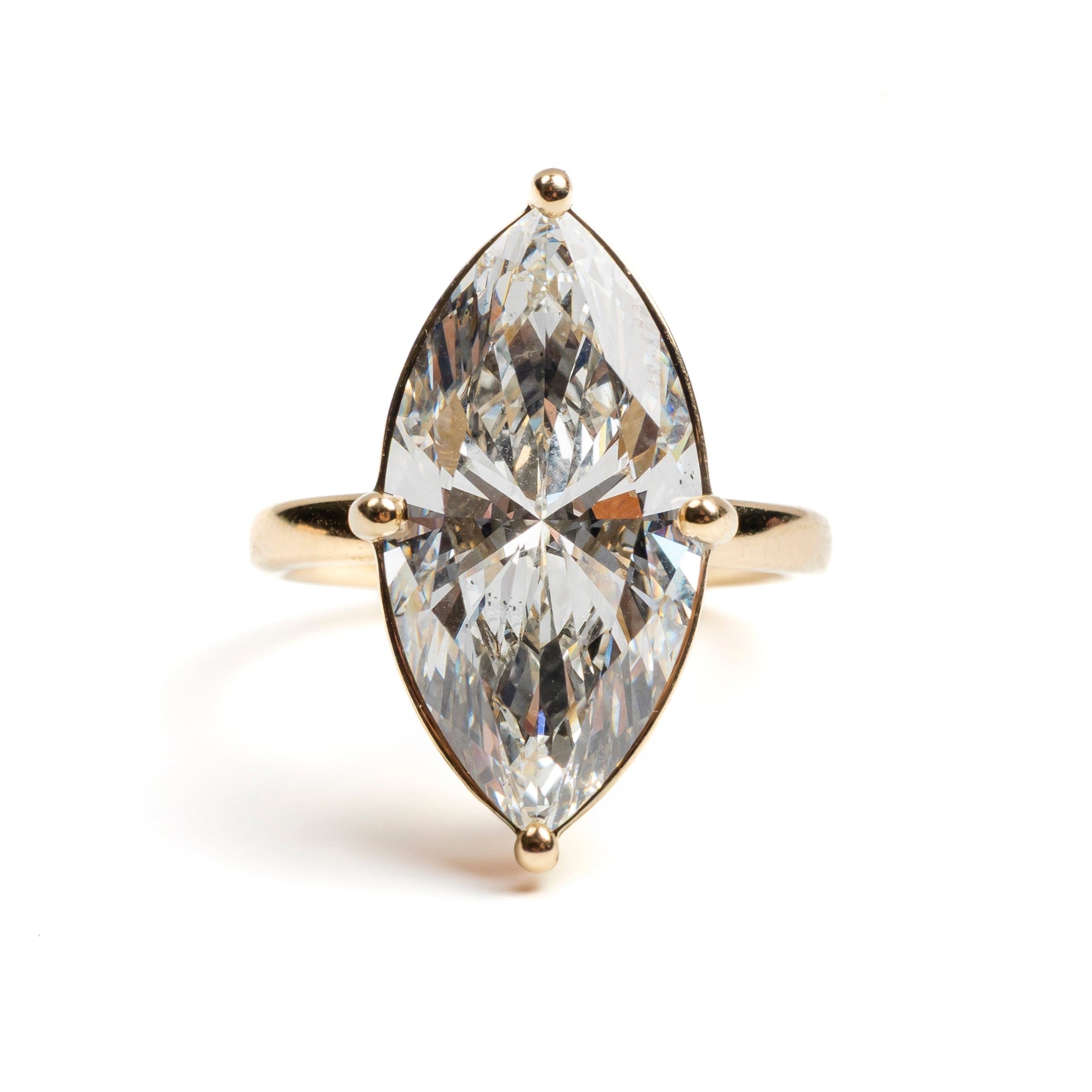 Gold ring with a marquise-shaped diamond on a white background