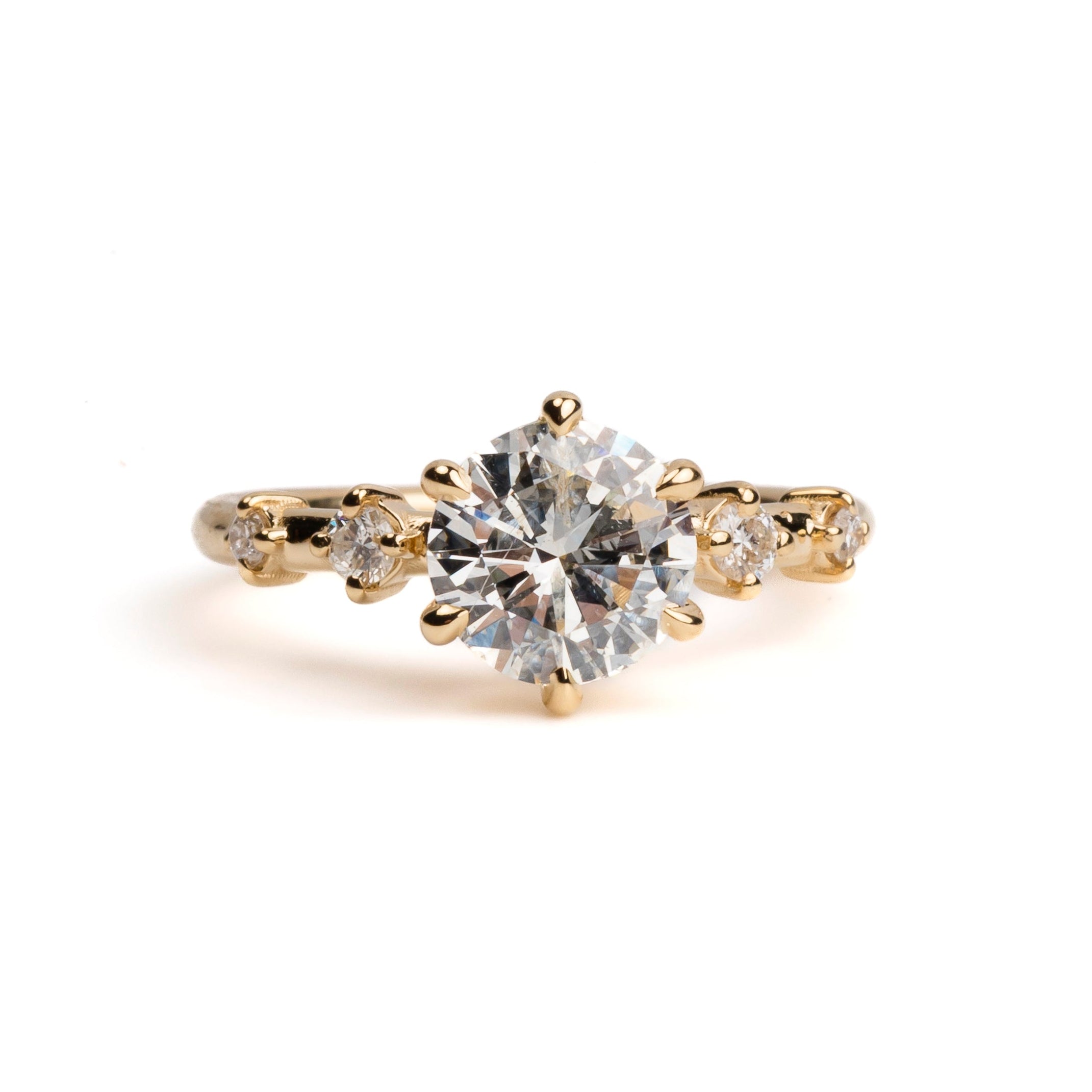 Gold ring with a large diamond on a white background